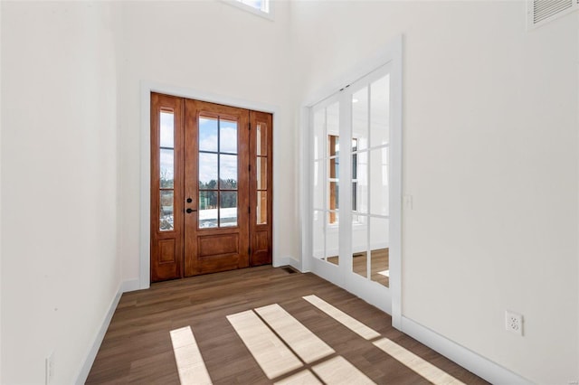 entrance foyer with a towering ceiling and dark wood-type flooring