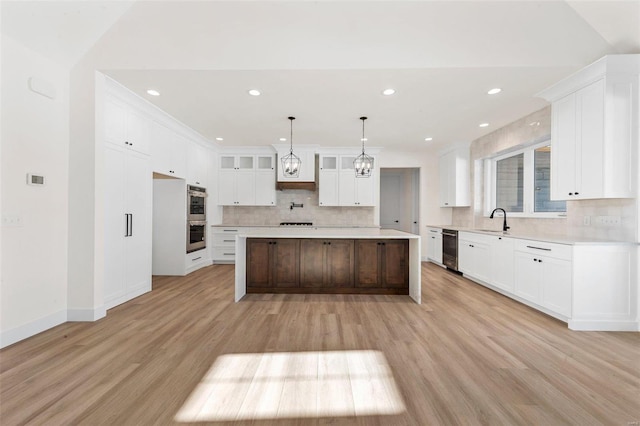 kitchen featuring a large island, light hardwood / wood-style floors, white cabinets, and sink