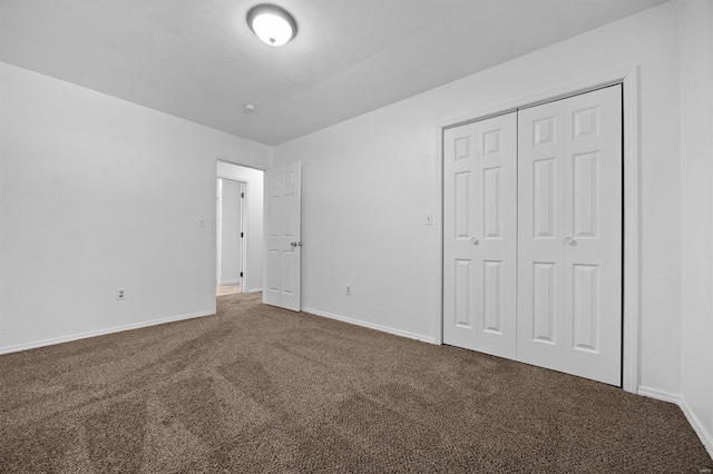 unfurnished bedroom featuring carpet flooring and a closet