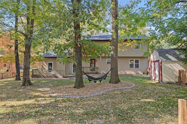 rear view of property featuring a shed and a lawn