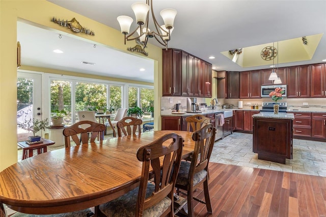 dining room featuring light hardwood / wood-style floors, sink, and an inviting chandelier