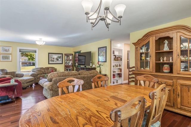 dining space featuring dark wood-type flooring and an inviting chandelier