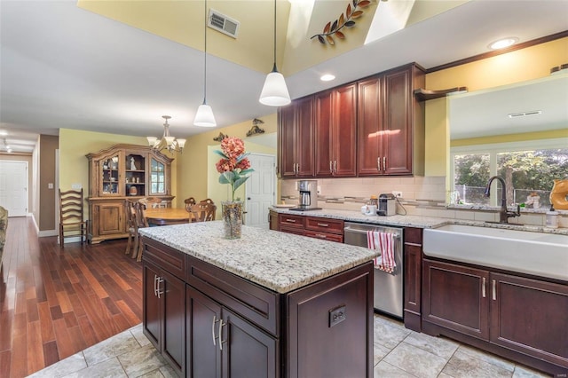 kitchen featuring sink, light wood-type flooring, a center island, pendant lighting, and dishwasher