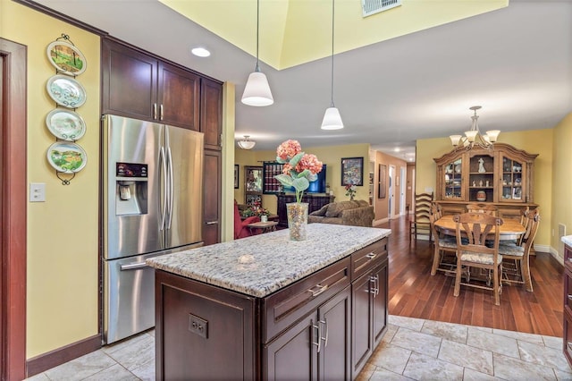 kitchen with light wood-type flooring, decorative light fixtures, a center island, and stainless steel fridge