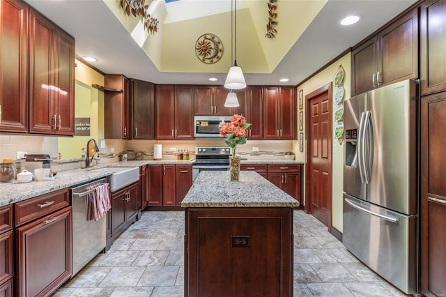 kitchen featuring a kitchen island, appliances with stainless steel finishes, pendant lighting, sink, and light stone countertops