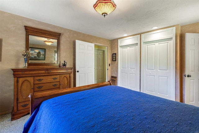 unfurnished bedroom featuring multiple closets and carpet flooring