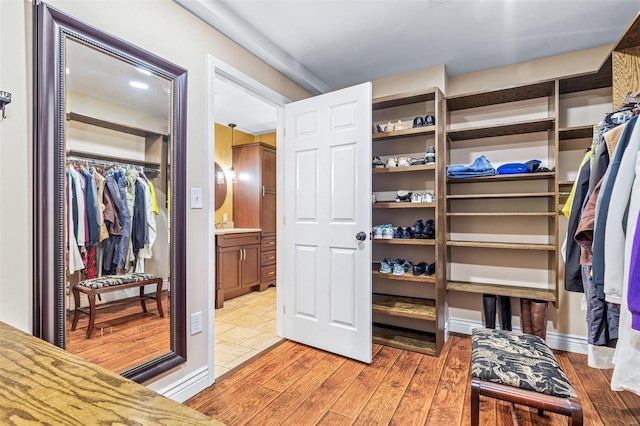 walk in closet with light wood-type flooring