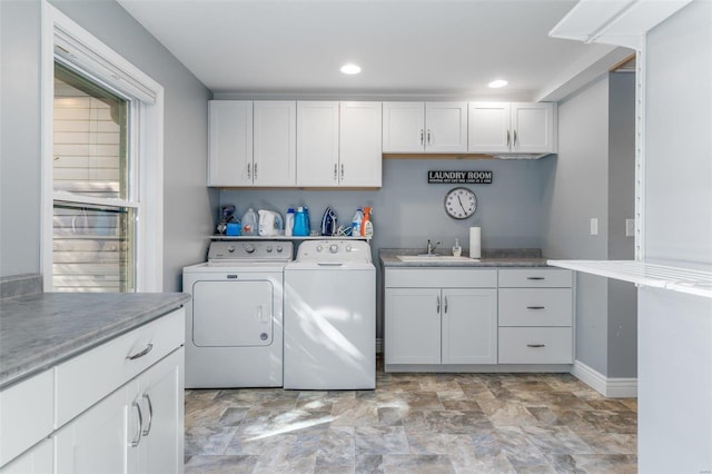 washroom featuring cabinets, sink, and washer and dryer