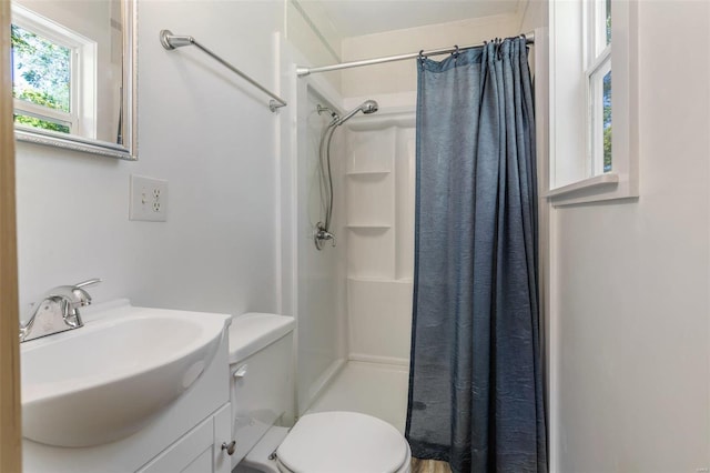 bathroom featuring a shower with shower curtain, vanity, and toilet