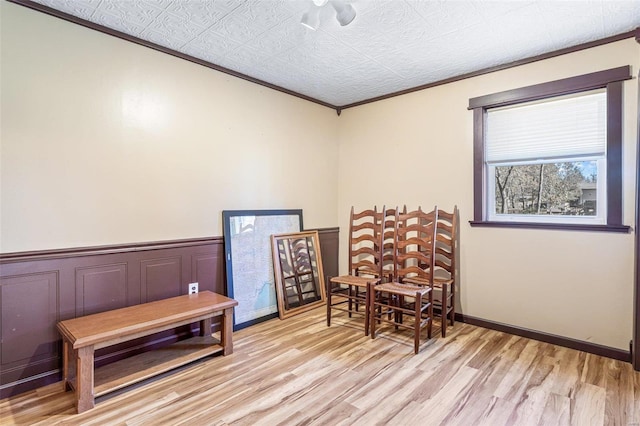 living area with light hardwood / wood-style floors and crown molding