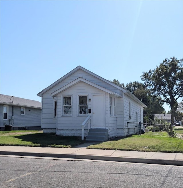 view of front of home with a front yard and cooling unit