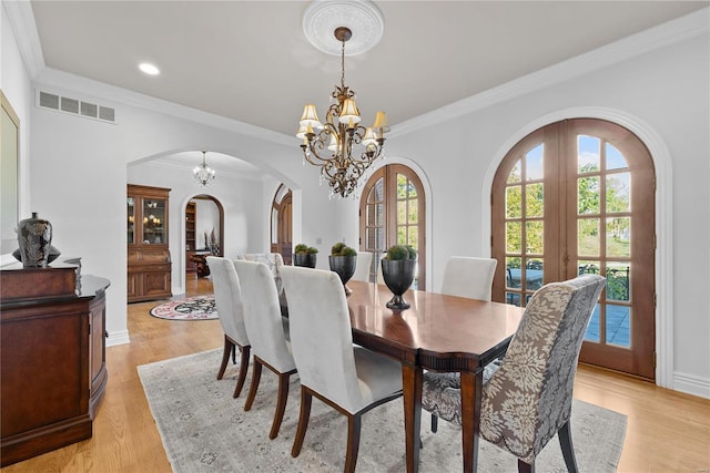 dining room with french doors, light wood-type flooring, and crown molding