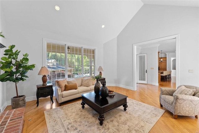 living room featuring crown molding, high vaulted ceiling, and hardwood / wood-style flooring