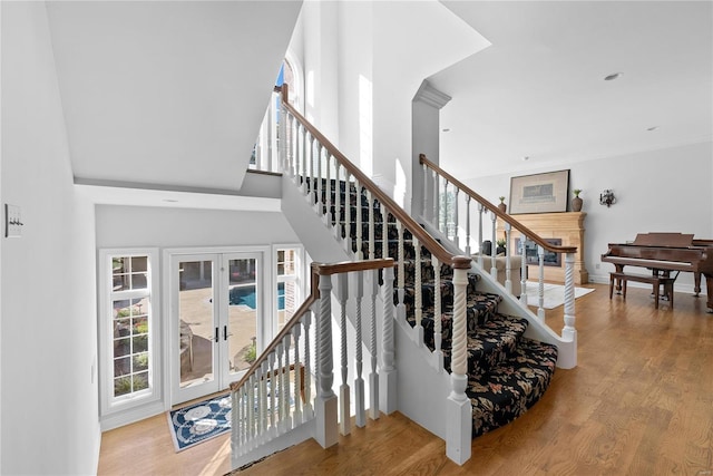 staircase featuring hardwood / wood-style floors and a high ceiling