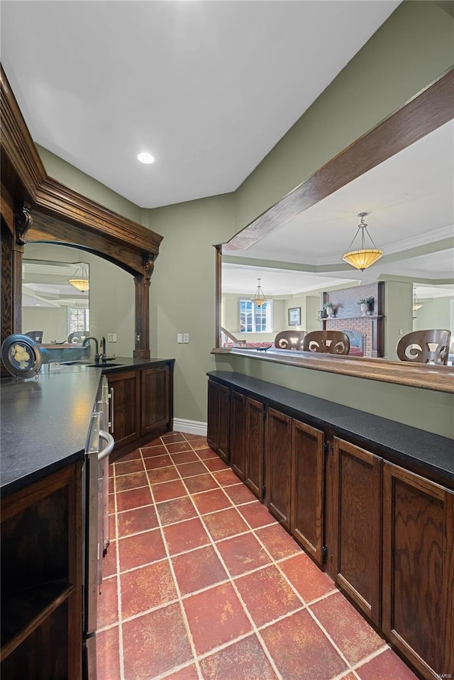 bar featuring dark brown cabinets, plenty of natural light, and sink