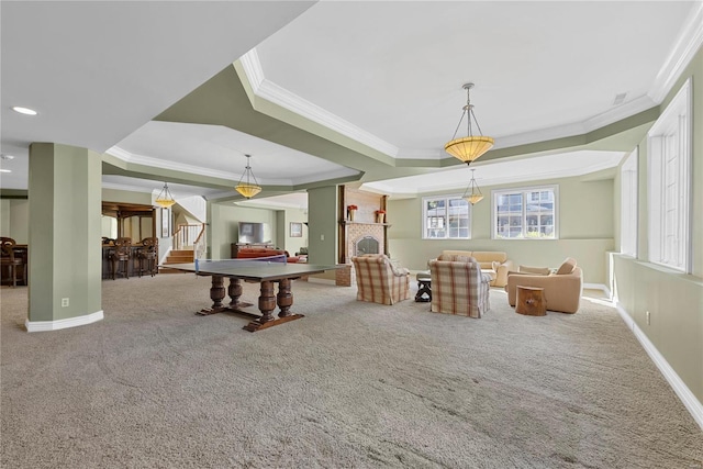 rec room with carpet, a fireplace, crown molding, and a tray ceiling