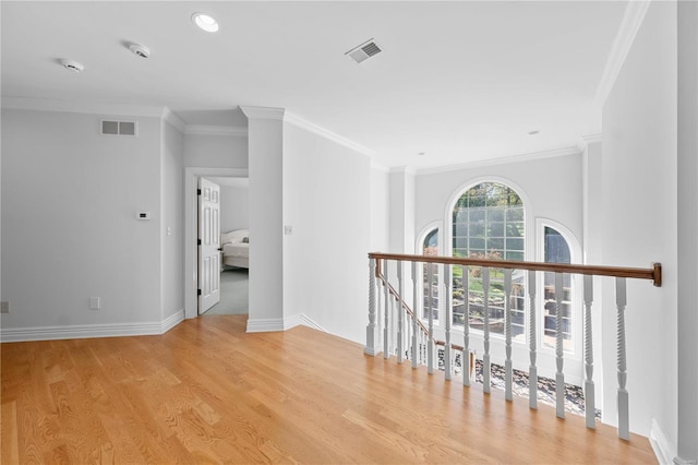 corridor with light wood-type flooring and ornamental molding