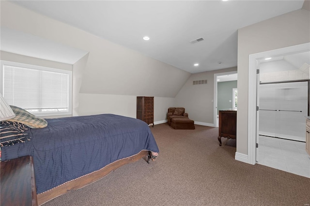 carpeted bedroom with vaulted ceiling and ensuite bath