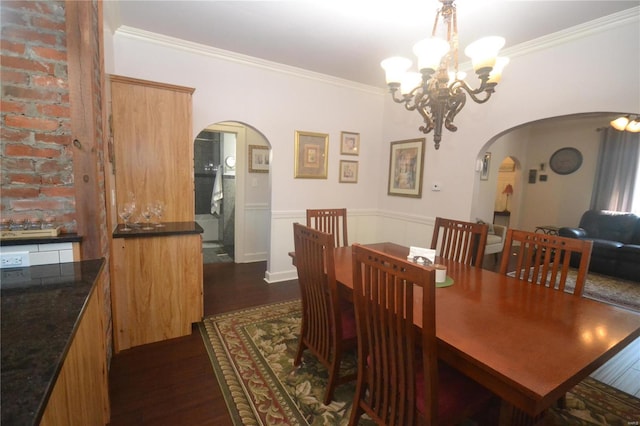 dining area featuring crown molding, a notable chandelier, and dark wood-type flooring