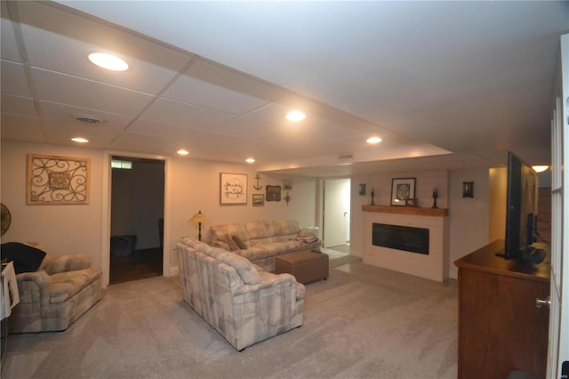 carpeted living room featuring a drop ceiling