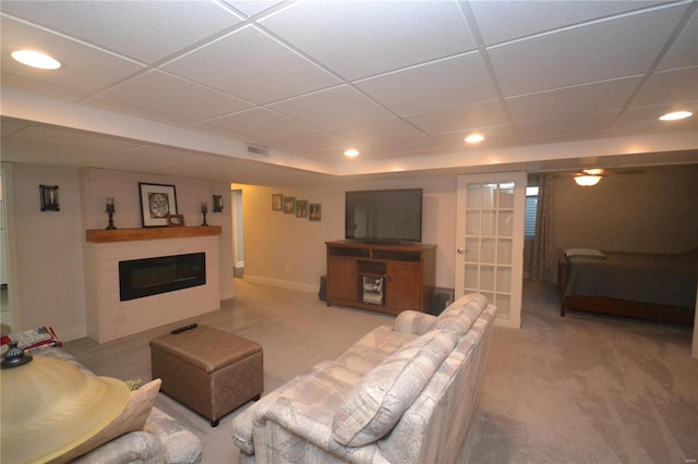 living room with a paneled ceiling and carpet flooring