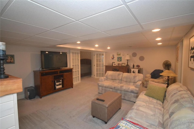 carpeted living room featuring a drop ceiling