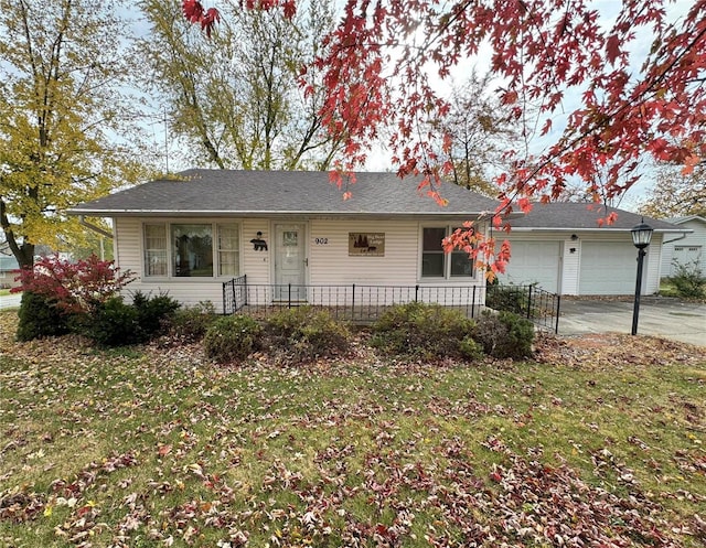 ranch-style house featuring a garage and a front lawn