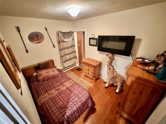 bedroom featuring a baseboard radiator and light hardwood / wood-style floors