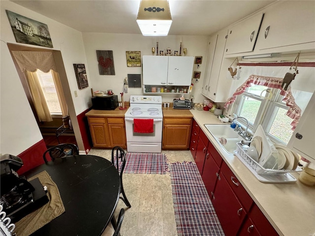 kitchen featuring white cabinets, white range with electric cooktop, and sink