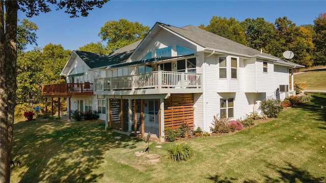 rear view of house with a lawn and a wooden deck