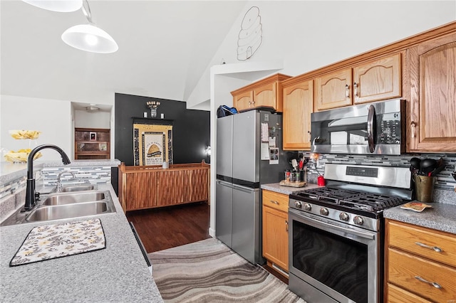 kitchen with lofted ceiling, dark wood-type flooring, sink, decorative backsplash, and appliances with stainless steel finishes