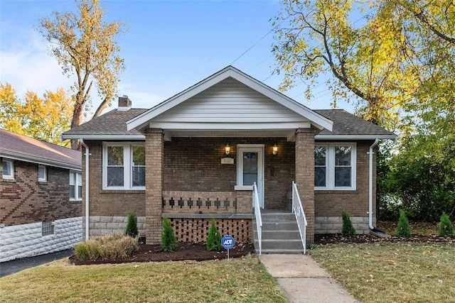 bungalow featuring a front lawn and a porch