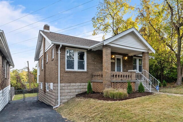 view of front facade featuring a front yard and covered porch