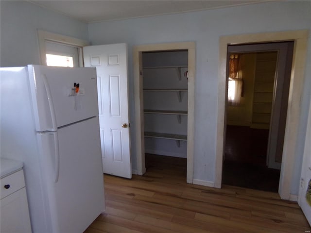 kitchen with light hardwood / wood-style flooring, white cabinetry, and white refrigerator