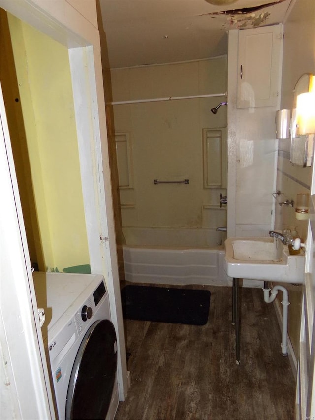 bathroom featuring bathtub / shower combination, washer / clothes dryer, sink, and hardwood / wood-style floors