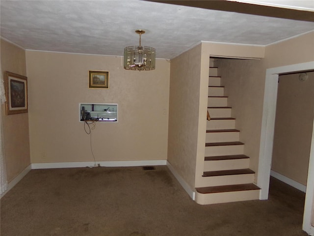 basement featuring a textured ceiling, a chandelier, and dark colored carpet