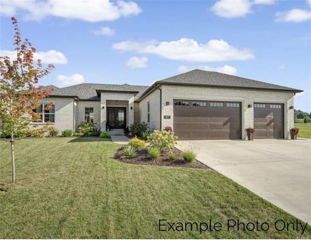 prairie-style house featuring a front lawn and a garage