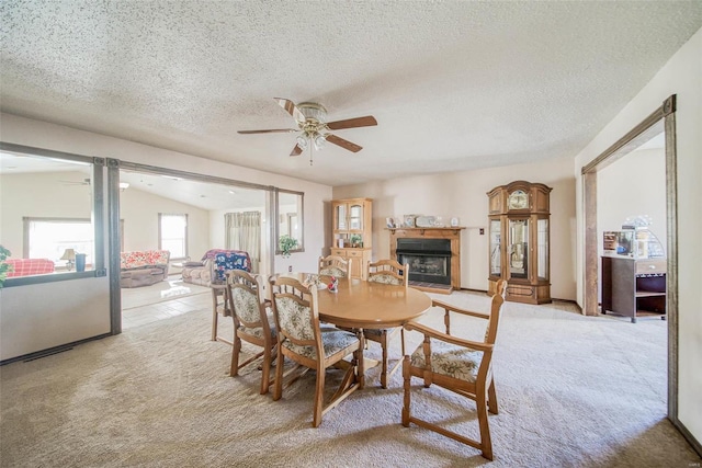 dining room with vaulted ceiling, ceiling fan, light carpet, and a textured ceiling