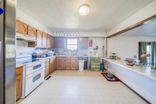 kitchen featuring stainless steel fridge, a textured ceiling, white range with electric stovetop, and sink