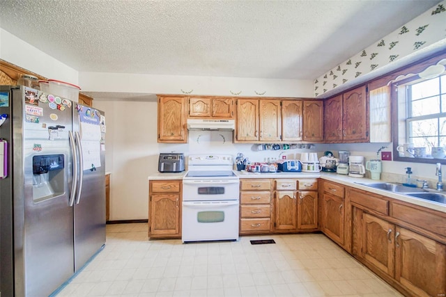 kitchen with stainless steel fridge, sink, a textured ceiling, and white electric stove