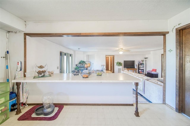 kitchen with a textured ceiling, kitchen peninsula, and a breakfast bar area