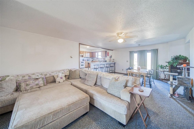 carpeted living room featuring a textured ceiling and ceiling fan