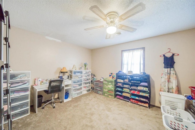 office area with carpet flooring, ceiling fan, and a textured ceiling