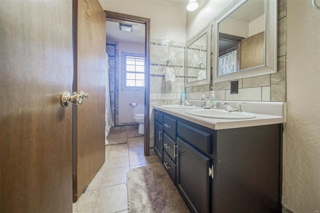 bathroom featuring tasteful backsplash, tile patterned floors, vanity, and toilet