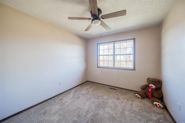 carpeted empty room with a textured ceiling and ceiling fan