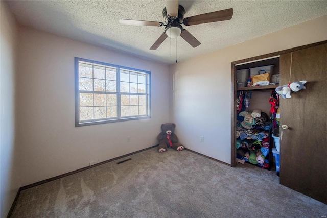 unfurnished bedroom featuring ceiling fan, carpet floors, and a textured ceiling