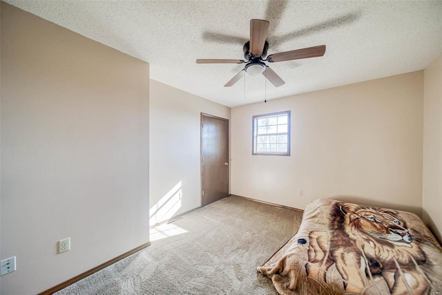 unfurnished bedroom featuring light carpet, a textured ceiling, and ceiling fan