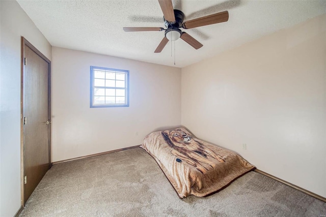 unfurnished bedroom featuring ceiling fan, light carpet, and a textured ceiling