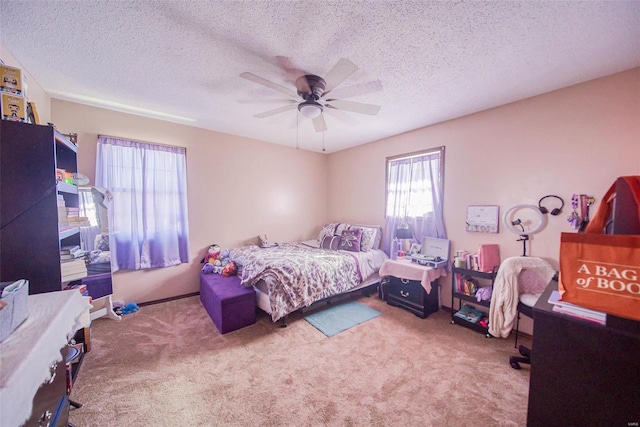 bedroom featuring ceiling fan, light colored carpet, and a textured ceiling