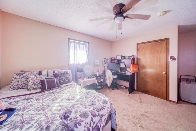 carpeted bedroom featuring ceiling fan and a textured ceiling